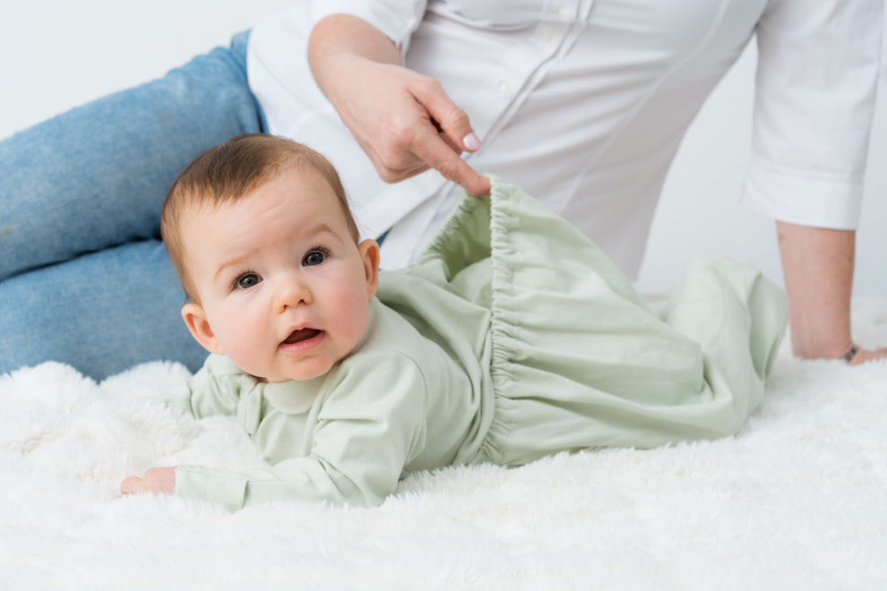 Baby wearing Dream Suit long sleeve organic zip suit lying peacefully on a soft blanket